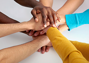 Photo of hands placed one on top of the other to symbolise collaboration